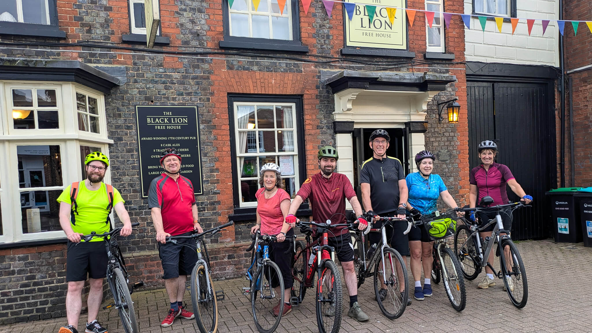 7 cyclists holding bikes after a group ride Leighton BuzzCycles